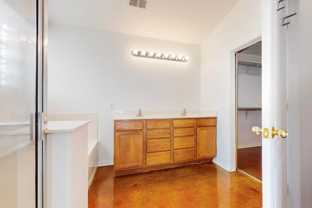 bathroom featuring a washtub, vanity, and concrete floors