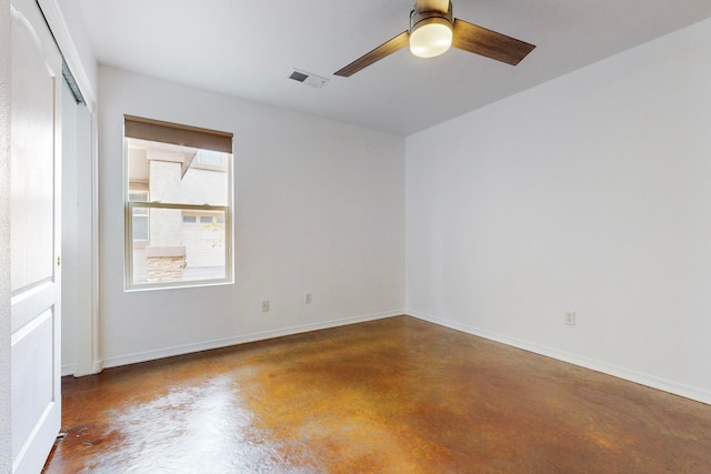 spare room with ceiling fan and concrete floors