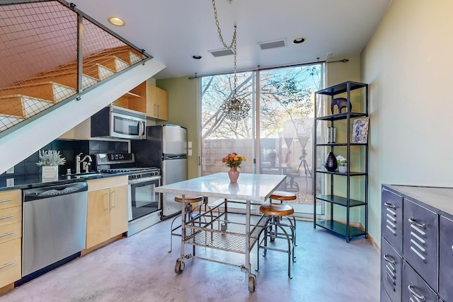 kitchen featuring sink, stainless steel appliances, light brown cabinetry, and tasteful backsplash