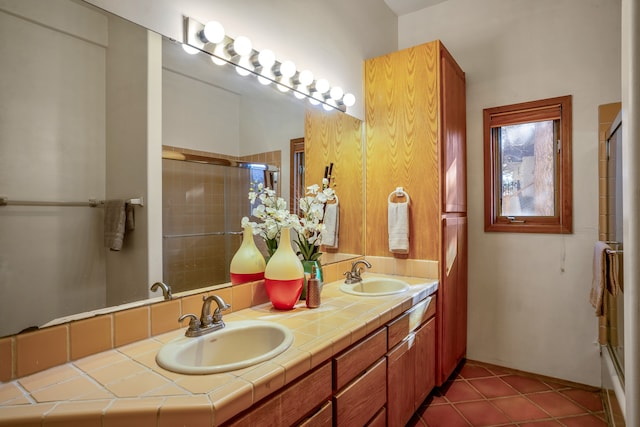 bathroom with tile patterned floors, shower / bath combination with glass door, and vanity