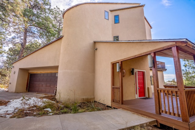 exterior space featuring a garage and a wooden deck