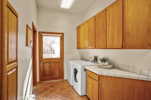 washroom featuring tile patterned floors, cabinets, a baseboard radiator, and washing machine and clothes dryer