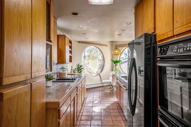 kitchen featuring backsplash, black appliances, and a baseboard heating unit