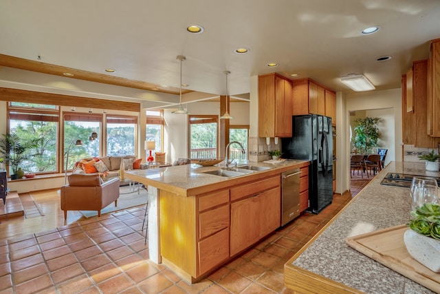 kitchen featuring sink, hanging light fixtures, tasteful backsplash, kitchen peninsula, and stainless steel appliances