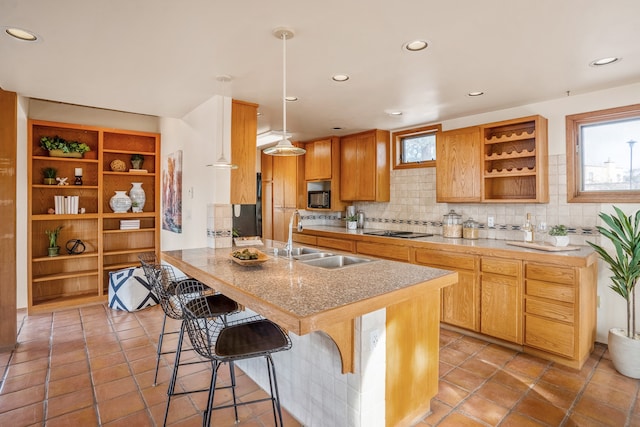 kitchen featuring decorative backsplash, sink, hanging light fixtures, and a wealth of natural light