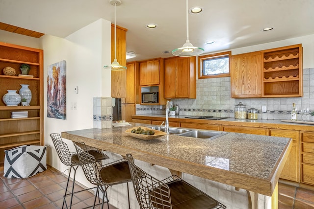 kitchen featuring pendant lighting, kitchen peninsula, a breakfast bar area, and tasteful backsplash