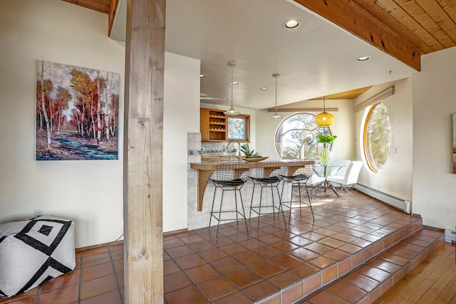 interior space featuring dark hardwood / wood-style flooring, wood ceiling, vaulted ceiling, a baseboard heating unit, and sink