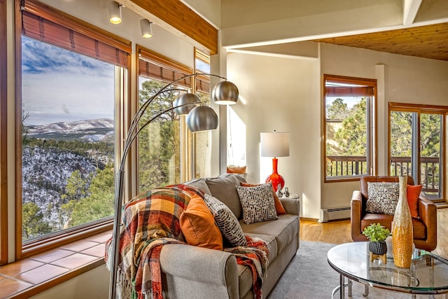 sunroom featuring a mountain view, beamed ceiling, and a baseboard radiator