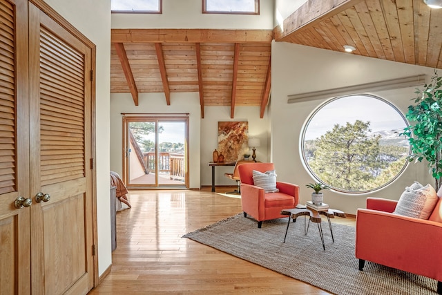 sitting room with lofted ceiling with beams, light hardwood / wood-style floors, and wooden ceiling