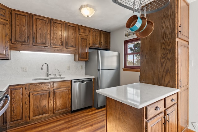 kitchen featuring decorative backsplash, sink, wood-type flooring, and appliances with stainless steel finishes