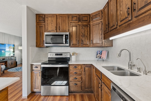 kitchen featuring decorative backsplash, light hardwood / wood-style floors, sink, and stainless steel appliances