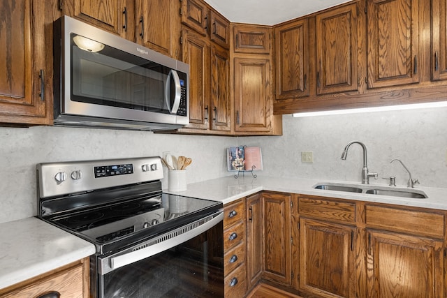 kitchen featuring appliances with stainless steel finishes, tasteful backsplash, and sink