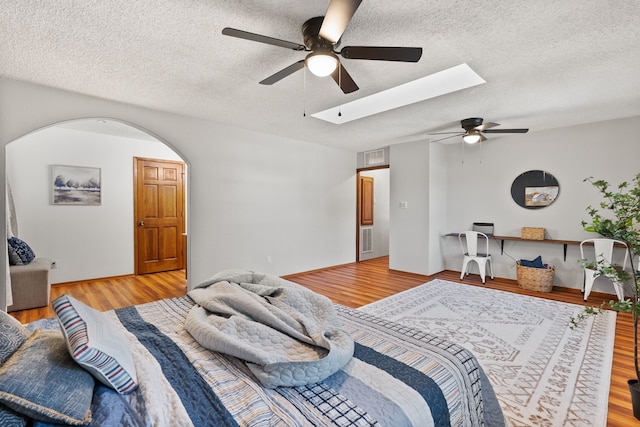 bedroom featuring ceiling fan, a textured ceiling, and light wood-type flooring