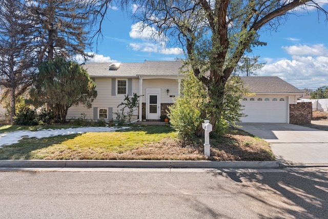 bi-level home with a garage and a front lawn