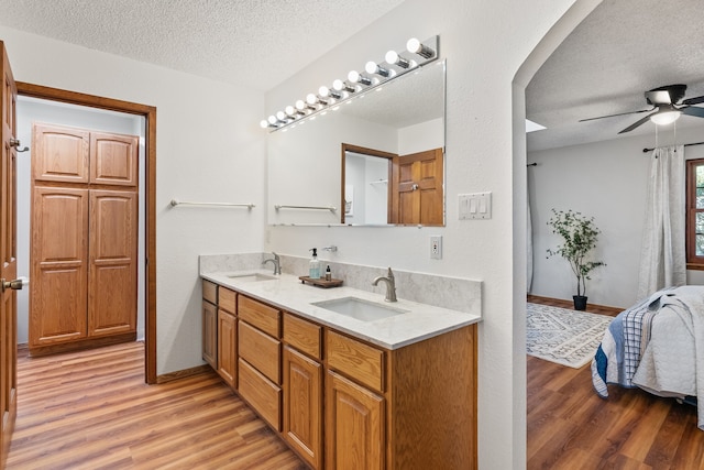 bathroom with vanity, hardwood / wood-style floors, a textured ceiling, and ceiling fan