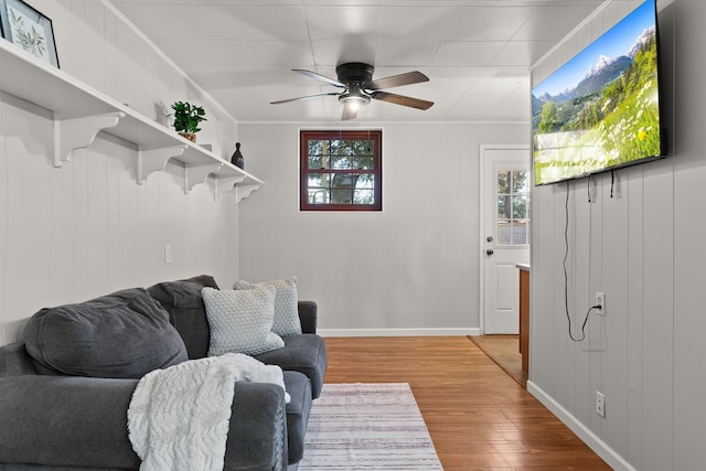 living room featuring ceiling fan, crown molding, and wood-type flooring