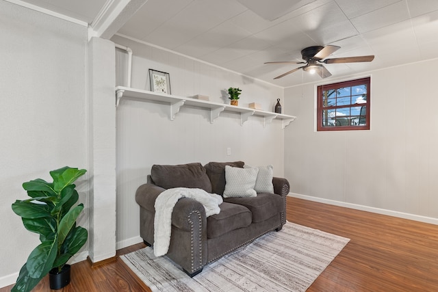 living area featuring hardwood / wood-style floors, ceiling fan, and crown molding