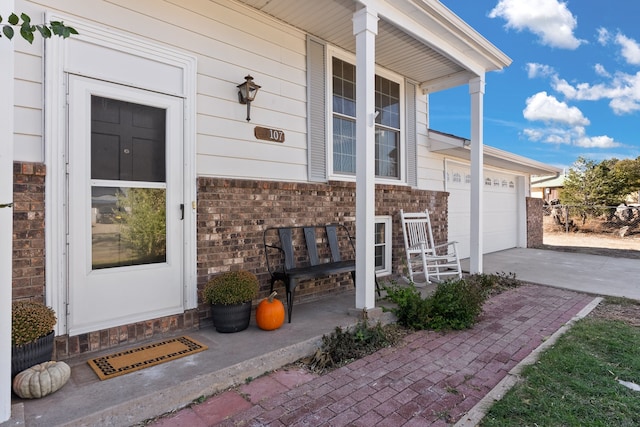 doorway to property featuring a garage and covered porch