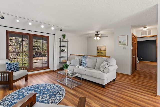 living room with hardwood / wood-style floors, a textured ceiling, and ceiling fan