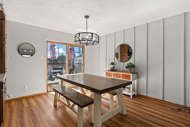 dining area with a notable chandelier, a textured ceiling, and hardwood / wood-style flooring