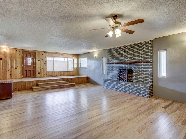 unfurnished living room featuring light hardwood / wood-style flooring, a healthy amount of sunlight, and a textured ceiling