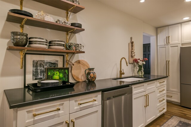 kitchen with dark hardwood / wood-style flooring, sink, white cabinetry, and stainless steel appliances