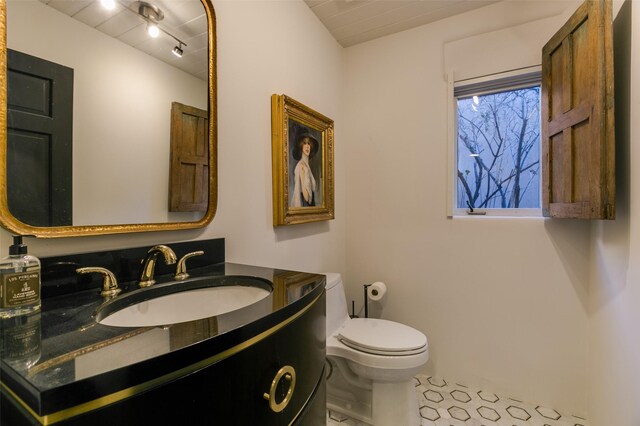 bathroom featuring tile patterned floors, vanity, and toilet