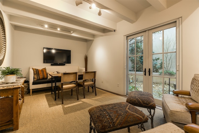 carpeted living room featuring beam ceiling, french doors, and track lighting