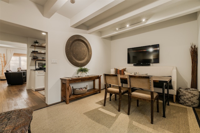 dining space featuring beam ceiling and light wood-type flooring