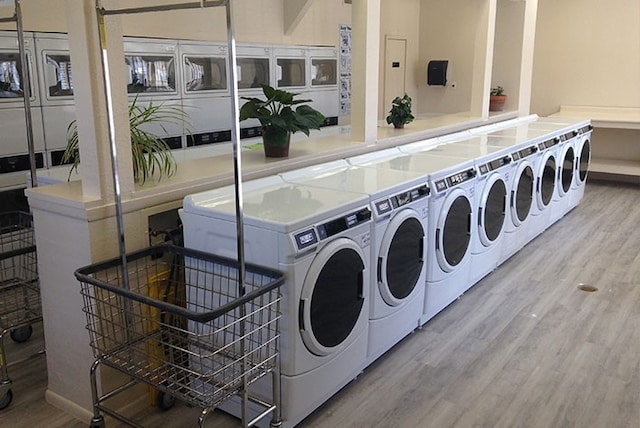 washroom with washer and clothes dryer and hardwood / wood-style flooring