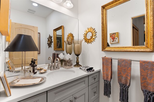 full bath with double vanity, visible vents, connected bathroom, wood finished floors, and a sink