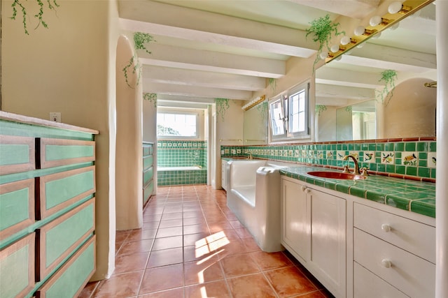 bathroom featuring tile patterned floors, vanity, beam ceiling, and tasteful backsplash