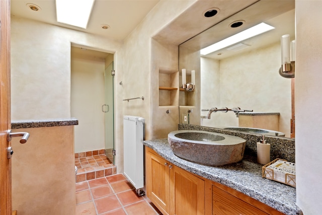 bathroom with radiator heating unit, vanity, tile patterned floors, and an enclosed shower