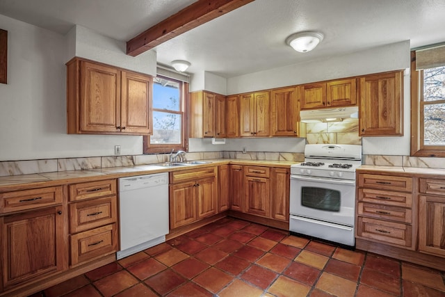 kitchen with beam ceiling, sink, a healthy amount of sunlight, and white appliances