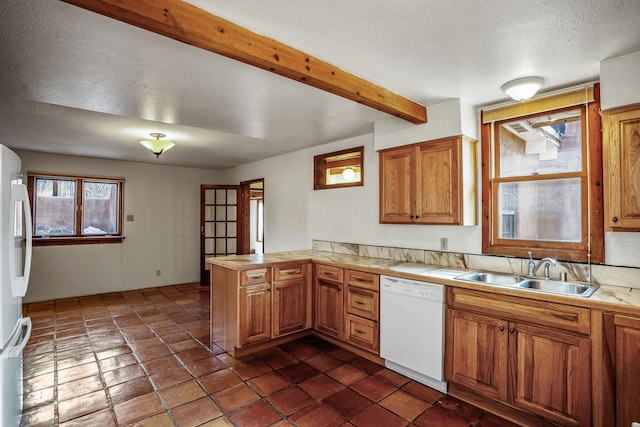 kitchen with white appliances, sink, a textured ceiling, beam ceiling, and kitchen peninsula