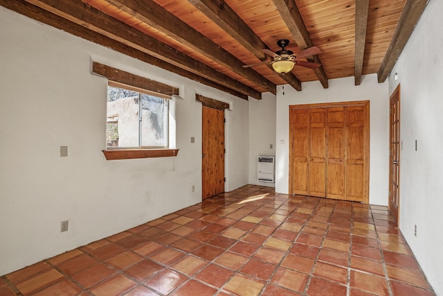 tiled empty room with beamed ceiling, heating unit, ceiling fan, and wood ceiling