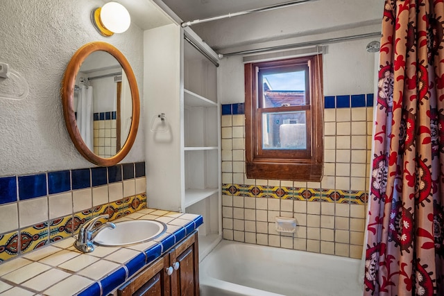 bathroom with shower / bath combination with curtain, vanity, and tile walls