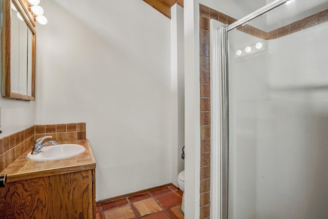 bathroom with vanity, toilet, and a shower with door