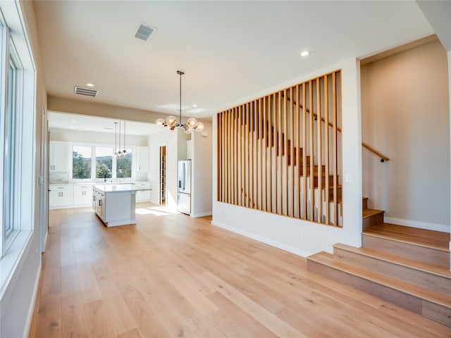 interior space with light hardwood / wood-style floors, a notable chandelier, and sink