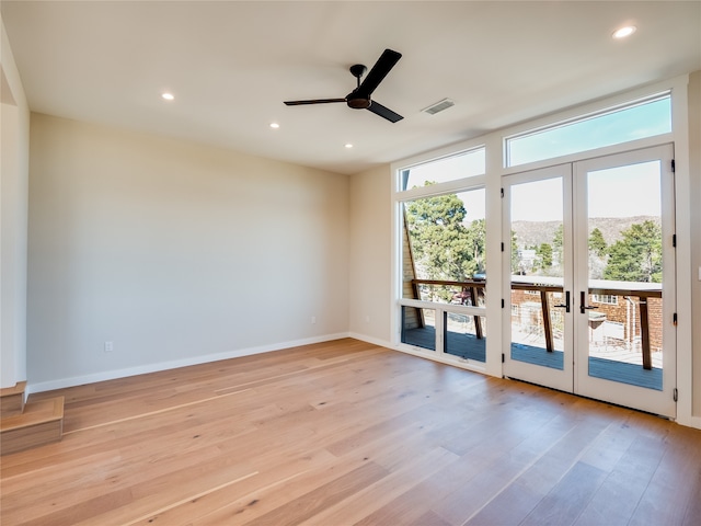 spare room with ceiling fan, a healthy amount of sunlight, light wood-type flooring, and french doors