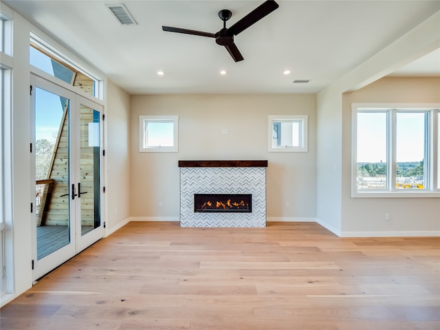 unfurnished living room featuring a fireplace, light hardwood / wood-style flooring, and ceiling fan