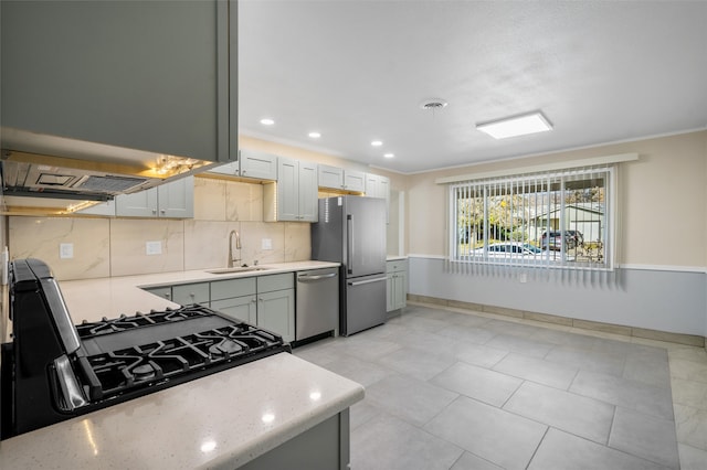 kitchen with sink, backsplash, crown molding, light tile patterned flooring, and appliances with stainless steel finishes