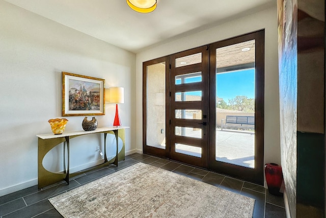 entrance foyer with dark tile patterned flooring and french doors