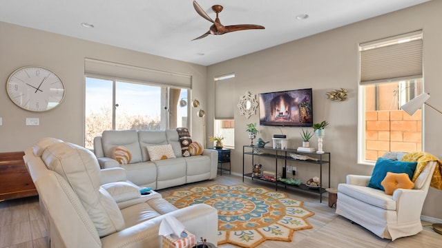 living area with recessed lighting, baseboards, and a ceiling fan