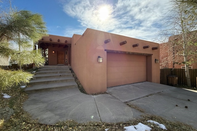 pueblo-style house featuring a garage