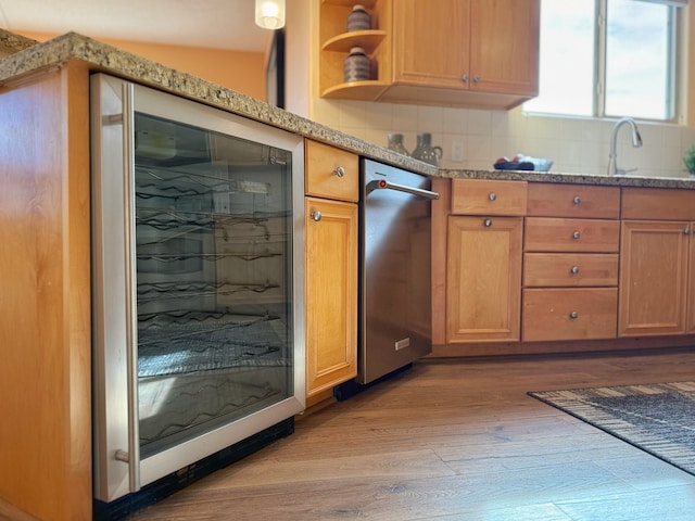 kitchen featuring sink, beverage cooler, light hardwood / wood-style flooring, backsplash, and lofted ceiling