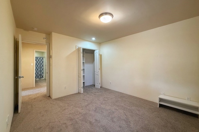 unfurnished bedroom with light carpet and a closet