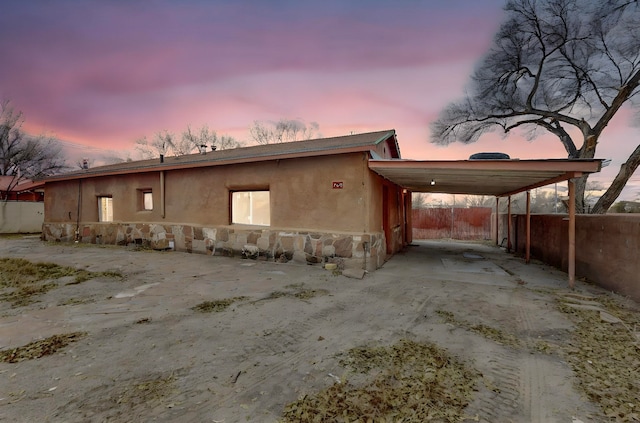 property exterior at dusk featuring a carport