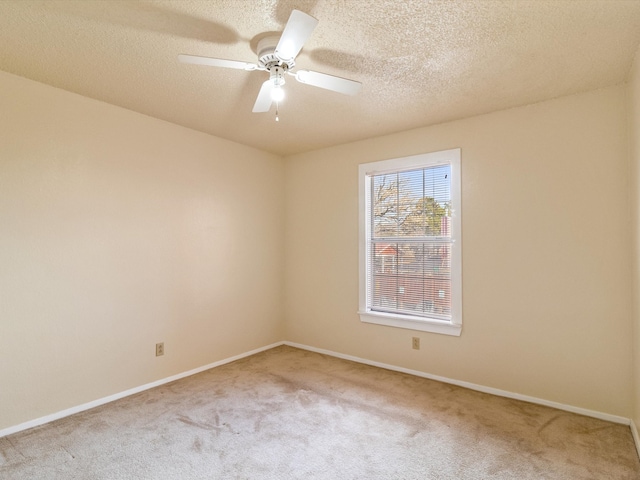 carpeted empty room with ceiling fan and a textured ceiling