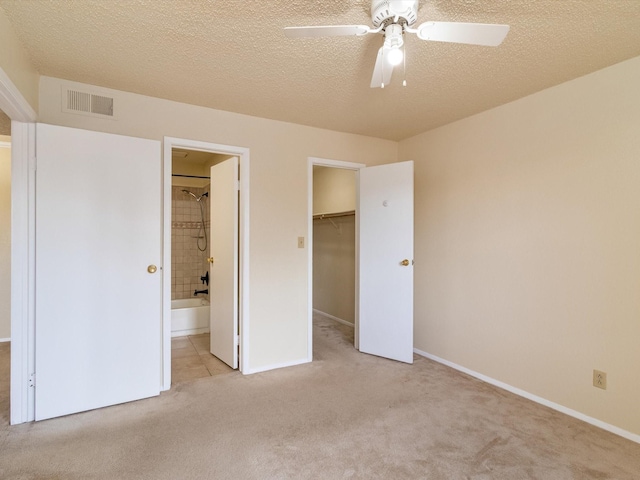 2501 Zia Rd Unit 10-210, Santa Fe, NM 87505 - unfurnished bedroom with a walk in closet, carpet, baseboards, visible vents, and a closet